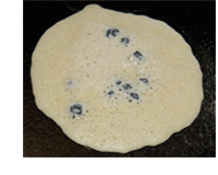 Picture of Blueberry Pancake showing right amount of bubbles before turning